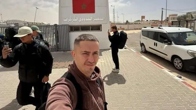 Tom Ruck prend un selfie devant le poste frontière de Guerguerat entre le Sahara occidental et la Mauritanie.