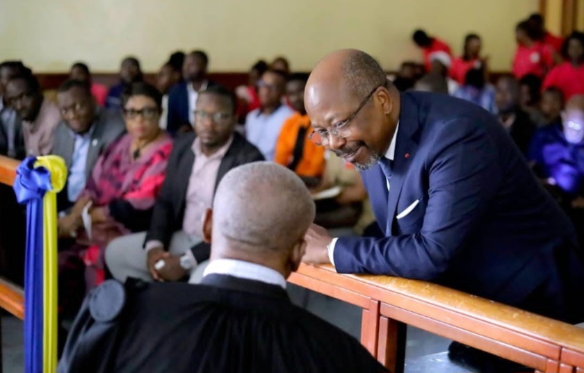 Bilie By Nze entouré de son avocat lors d'une audience
