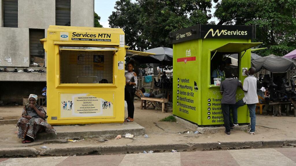 Cabines de mobile money dans un quartier animé d'Abidjan