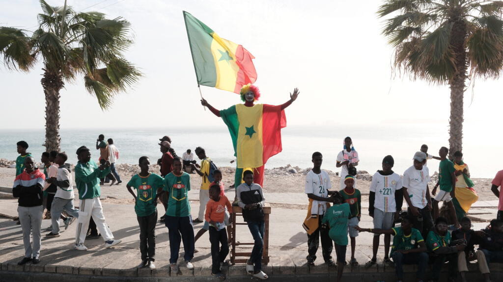 Supporters sénégalais célébrant lors d'un défilé à Dakar en janvier 2026, illustration des passions footballistiques locales